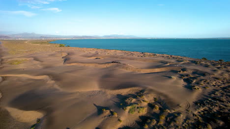 Orbitale-Drohnenaufnahme-Von-Menschen,-Die-Sandboard-In-Den-Dünen-Von-Mogote-In-Baja-California-Sur-Mexico-üben