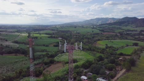 Pair-of-cell-phone-towers-in-the-middle-of-a-rural-setting-in-El-Salvador---Aerial-orbital