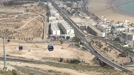 Cable-car-of-the-aerial-tramway-connecting-Oufella-peak-and-Agadir-city-in-Morocco,-overlooking-a-panoramic-view-of-the-beach-13