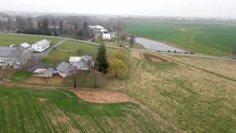 An-aerial-shot-of-the-gloomy-farmlands-in-Pennsylvania-with-trucks-driving-by-and-delivering-commodities