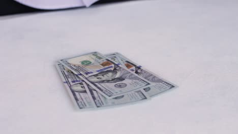 Persona-Contando-Billetes-De-Cien-Dólares-Sobre-La-Mesa