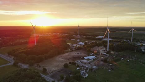 Luftaufnahme-Von-Windmühlen,-Die-Auf-Rhode-Island-Strom-Erzeugen-Und-In-Den-Sonnenuntergang-Hineinarbeiten