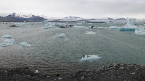 Laguna-Glaciar-En-Islandia-Con-Vista-Lateral-Del-Fotógrafo-Masculino-Y-Pan-De-Izquierda-A-Derecha