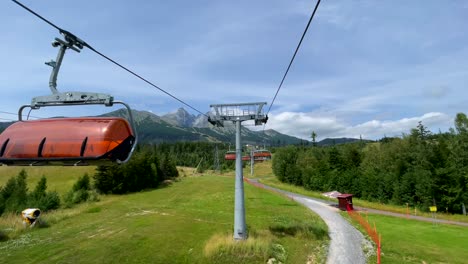 Chair-lift-over-green-forested-landscape,-High-Tatras-background,-Slovakia