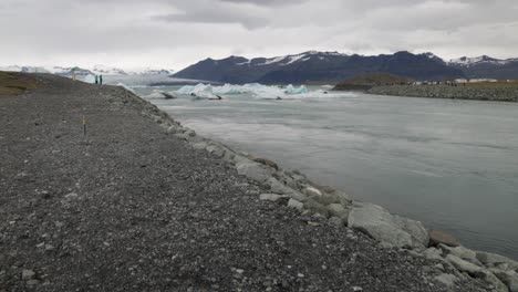 Laguna-Glaciar-En-Islandia-Con-Rocas-Y-Río-Con-Video-Cardán-Caminando-Hacia-Adelante