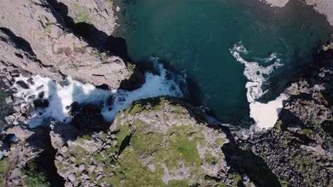 Dron-Volando-En-Círculo-Con-La-Cámara-Inclinada-Hacia-Abajo-Sobre-Una-Cascada-En-Islandia-4k