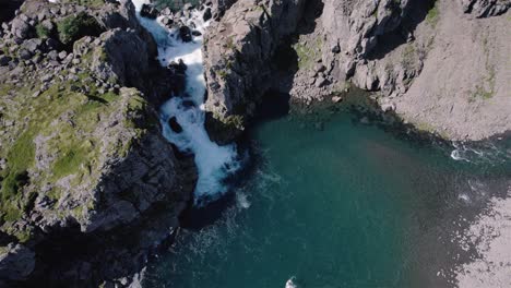 Tiro-De-Drone-Girando-Con-La-Cámara-Inclinándose-Lentamente-Sobre-Cascada-Y-Montañas-En-Islandia-4k
