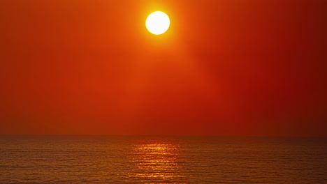 Zeitrafferaufnahme-Der-Sonne,-Die-Während-Der-Abendzeit-über-Dem-Horizont-Im-Hintergrund-über-Dem-Ozean-Herunterkommt