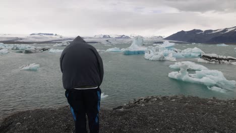 Glacier-Lagoon-in-Iceland-with-man-looking-and-gimbal-video-walking-behind