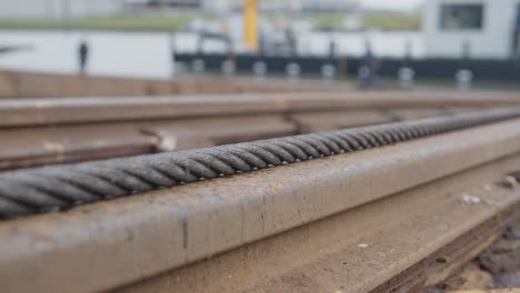 Rostige-Eisenkette,-Die-Im-Hafen-über-Eine-Schiene-Zieht