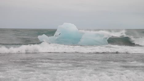 Glacier-Lagoon-in-Iceland-with-big-chunk-of-glacier-ice-in-ocean-with-big-waves
