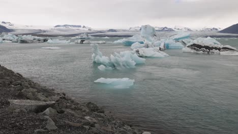 Glacier-Lagoon-in-Iceland-with-man-overlooking-and-gimbal-video-walking-behind