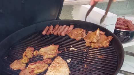Taking-off-minced-meat-fingers-called-cevapcici-from-charcoal-grill-with-steel-clamps