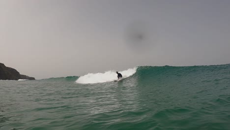 Hombre-Surfista-Montando-Con-Mucha-Fuerza-En-El-Labio-En-La-Playa-Con-Agua-Turquesa-Y-Vista-Aérea-De-Las-Olas