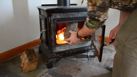 Warming-up-hands-in-front-of-a-woodburning-stove-fireplace-on-a-cold-winter-day