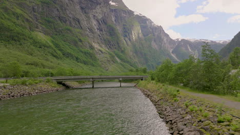 Puente-Sobre-El-Arroyo-En-Gudvangen-Durante-El-Día-Con-Una-Pintoresca-Montaña-En-Aurland,-Vestland,-Noruega