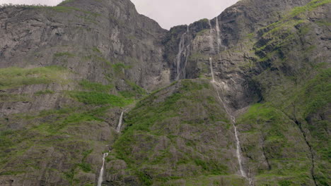 Majestic-Kjerrskredsfossen-falls-down-steep-mountainside-cliffs;-aerial
