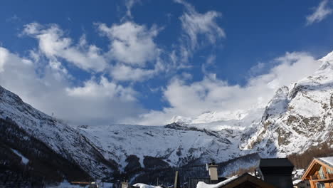 Timelapse-in-the-swiss-alps,-Village,-mountain-range-and-sky-with-moving-clouds