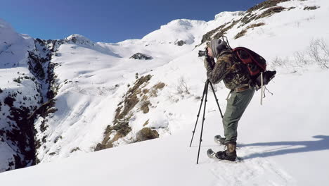 A-nature-and-wildlife-photographer-prepares-for-a-winter-photoshoot-in-the-snow-covered-mountains-of-Kodiak-Island-Alaska