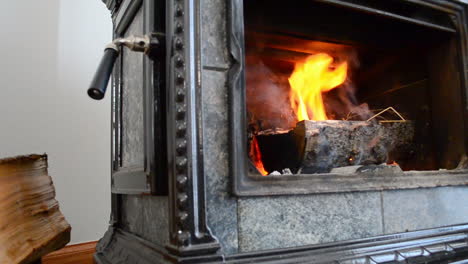 A-slider-shot-of-logs-on-fire-in-a-woodburning-stover-fireplace-on-a-cold-winter-day