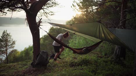 A-Tourist-Guy-Relaxing-Outdoors-Lying-On-A-Camping-Hammock-Hanging-On-A-Hillside