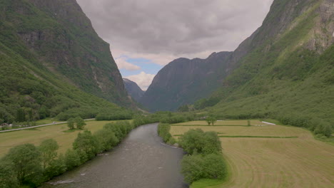 River-running-down-lush-Viking-Valley-in-Norwegian-fjord-landscape