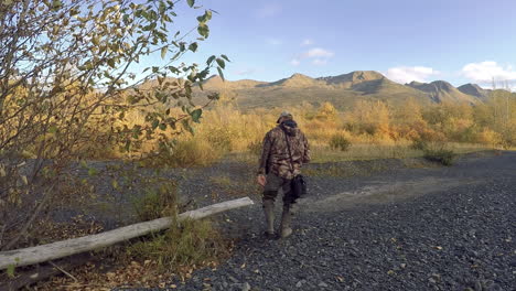 Un-Fotógrafo-De-Naturaleza-Y-Vida-Silvestre-Se-Sienta-Cerca-De-Un-Río-De-Salmón-Durante-Una-Sesión-De-Fotos-De-Otoño-En-El-Desierto-De-La-Isla-De-Kodiak,-Alaska