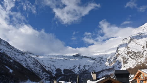 Timelapse:-Saas-Fee-village,-mountain-range-with-snowy-summits-of-the-alps-and-a-sky-with-moving-clouds,-Switzerland