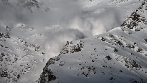 A-large-foggy-avalanche-is-going-down-ski-slopes,-Swiss-alps-Mountains,-science