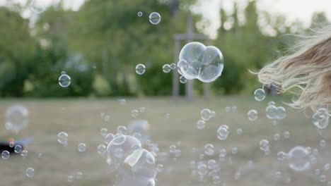 Children-makes-a-lot-of-soap-bubbles,-which-were-filmed-with-a-lot-of-fps