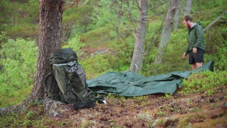 A-Male-Backpacker-Setting-Up-A-Camping-Hammock-In-The-Forest