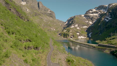 Paso-De-Montaña-A-Lo-Largo-De-Un-Lago-Tranquilo-Cerca-De-La-Carretera-Del-Túnel-En-Verano-En-El-Condado-De-Hordaland,-Noruega