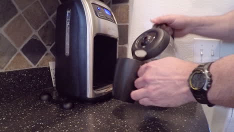 Pouring-a-fresh-morning-cup-of-coffee-from-a-coffeemaker-in-the-kitchen
