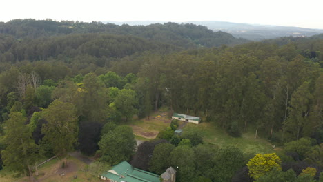 Aerial-tracking-over-regional-venue-as-cockatoos-fly-over-green-grass-lands-below