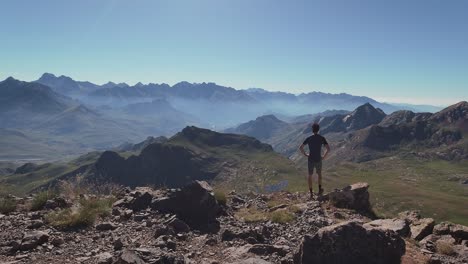 Young-hiker-standing-on-the-edge-of-Anayet-peak-and-enjoying-the-views-of-spanish-Pyrenees-and-Tena-Valley