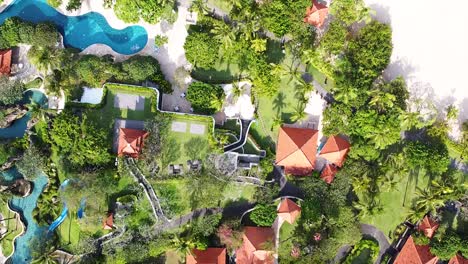 Aerial---birdseye-shot-of-beautiful-beach-front-resort,-white-sand,-pools-and-lush-jungle