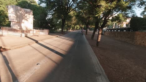Pov-Sevilla-Scooter-Eléctrico-Movilidad-Viaje-Temprano-En-La-Mañana-En-El-Parque-Con-Bicicletas-Y-Corredores