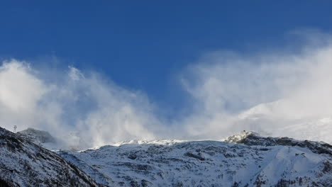 Timelapse:-moving-clouds-over-snowy-rocky-mountains-in-the-Swiss-alps,-Saas-Fee,-sunny-day