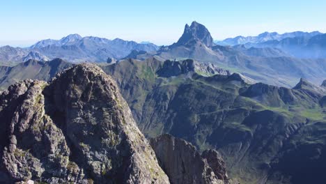 Aerial-view-anayet-peak-with-man-standing-on-top-drone-view-of-Spanish-and-French-Pyrenees-during-the-morning-un-Anayet-mountain-range-and-lake