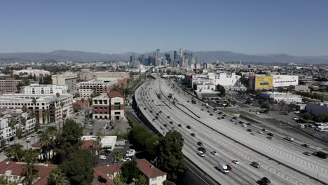 Wide-angle-drone-shot-flying-over-highway-to-Downtown-Los-Angeles-in-USA
