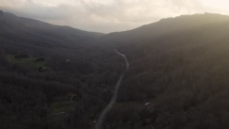 Drone-establishing-shot-of-rural-valley-between-mountains-with-a-single-road-in-North-Carolina