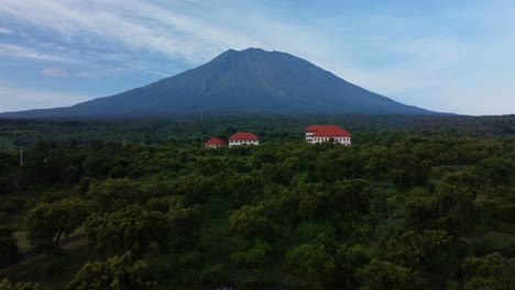 Fliegen-über-Ein-Tropisches-Dorf-Mit-Mount-Agung-Hintergrund,-Antenne