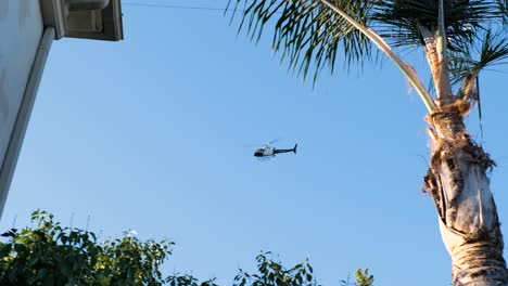 A-Police-Helicopter-Circling-A-House-in-LA-with-a-Blue-Sky