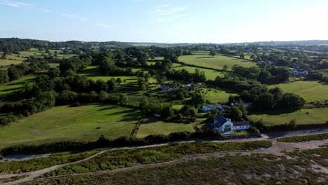 Aerial-view-rising-above-Traeth-Coch-Pentraeth-Welsh-rural-marshland-scenic-farming-countryside-at-sunset
