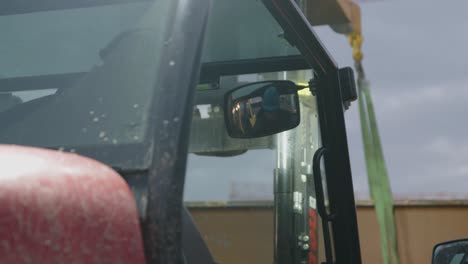 Close-up-of-a-man-driving-a-forklift-and-pointing-at-somethin-as-he-drives-towards-it-afterwards