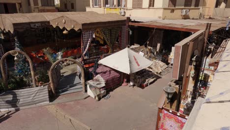 Fotografía-Cenital-De-Un-Mercado-Callejero-Con-Poca-Gente-Al-Mediodía-En-Un-Barrio-De-Luxor,-Egipto