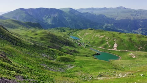 Mountain-Scenery-Aerial-–-Nature-Green-Meadows-Of-Valleys-With-Lakes-And-Village-In-Summer