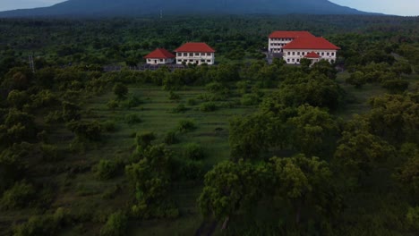 Drone-flying-through-jungle-revealing-Mount-Agung-Bali-and-school-around-forest