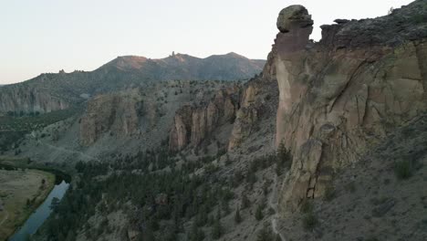 Aerial-cliff-side-view-approaching-Monkey-Face-at-Smith-Rock-at-sunrise