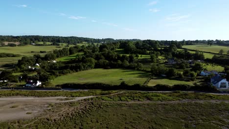 Aerial-rising-view-Traeth-Coch-Pentraeth-Welsh-rural-marshland-scenic-farming-countryside-at-sunset